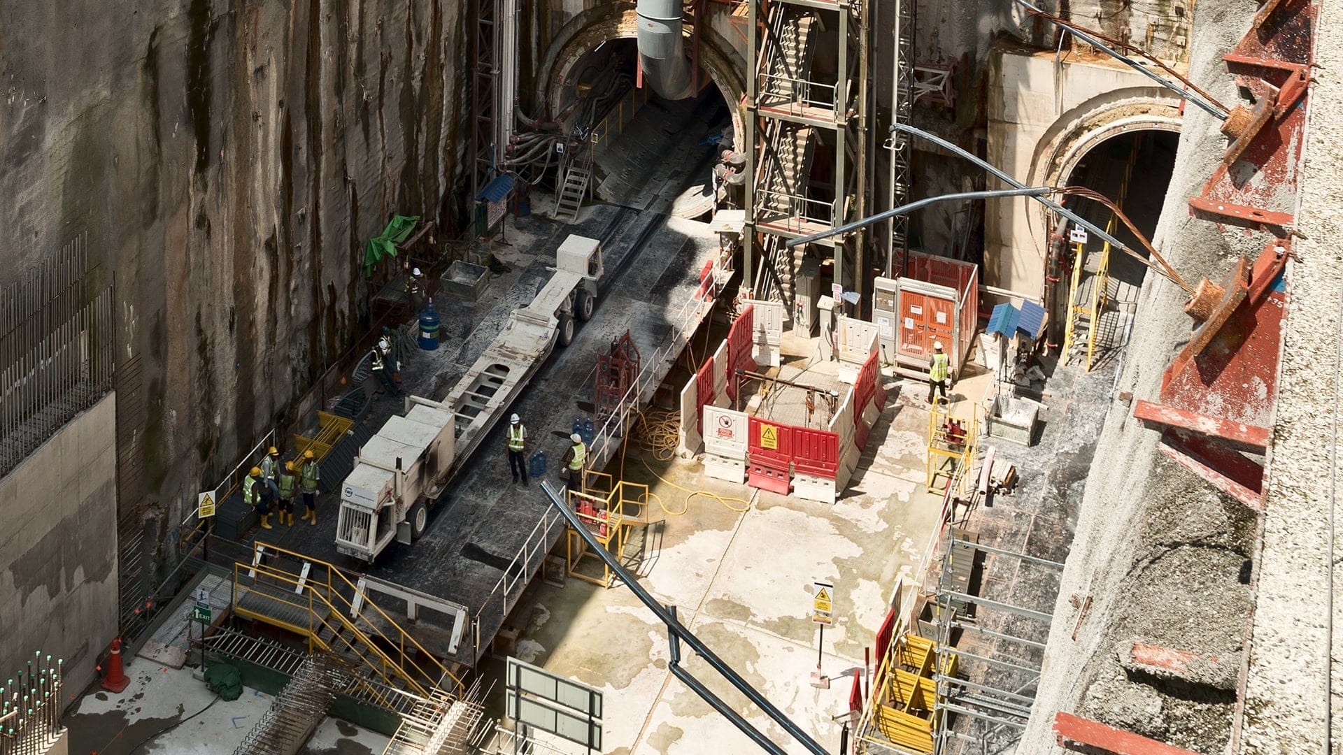 Tunnelbaustelle einer Multi-Mode TBM mit Blick in den Untergrund zur Tunnelröhre und Skyline im Hintergrund
