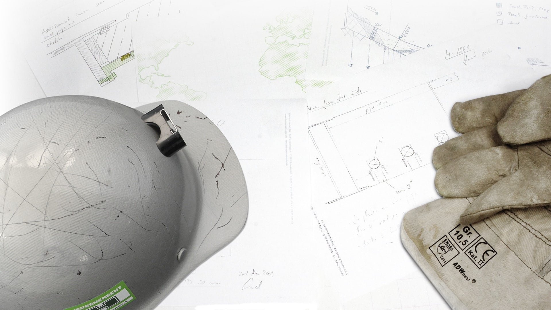 A Herrenknecht helmet with gloves lying on a project plan