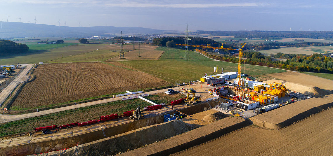 Picture of an E-Power Pipe construction site with fields around it and the Black Forest in the background.