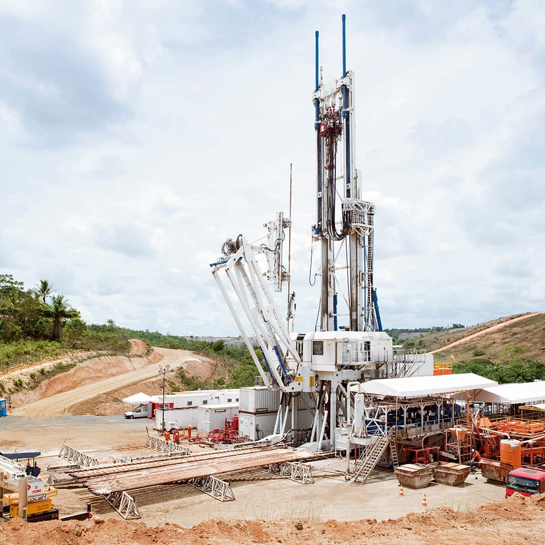 A white onshore deep drilling rig in operation on a construction site 
